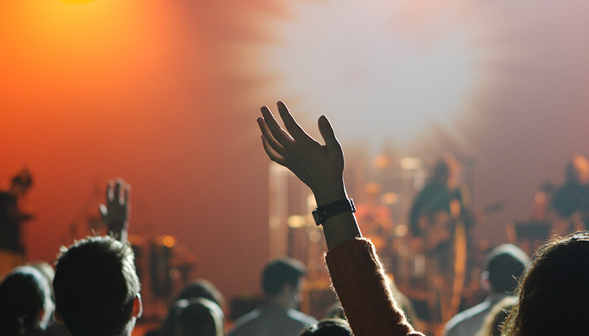 People holding hands in air at church worship service