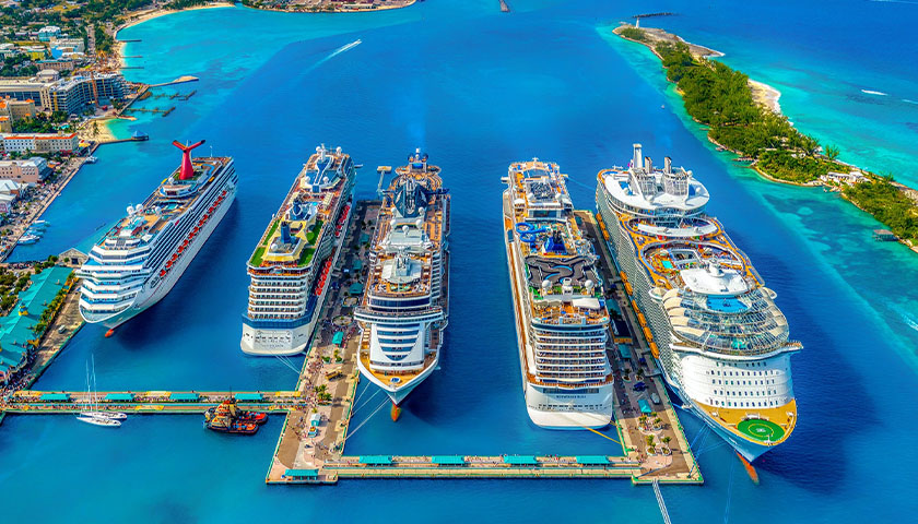 Aerial shot of several cruise ships in the ocean, clear water.