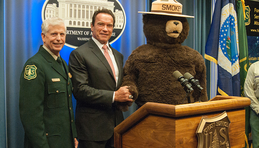 From left: U.S. Forest Service Chief Tom Tidwell, former California Governor Arnold Schwarzenegger and Smokey Bear pose during an event honoring Gov. Schwarzenegger as an honorary Forest Ranger at the U.S. Department of Agriculture in Washington, D.C. Wed., Oct. 29, 2013. Gov. Schwarzenegger is being honored for his signing and implementing the landmark California Global Warming Solutions Act of 2006 and continued leadership on climate change since leaving office. USDA photo by Bob Nichols